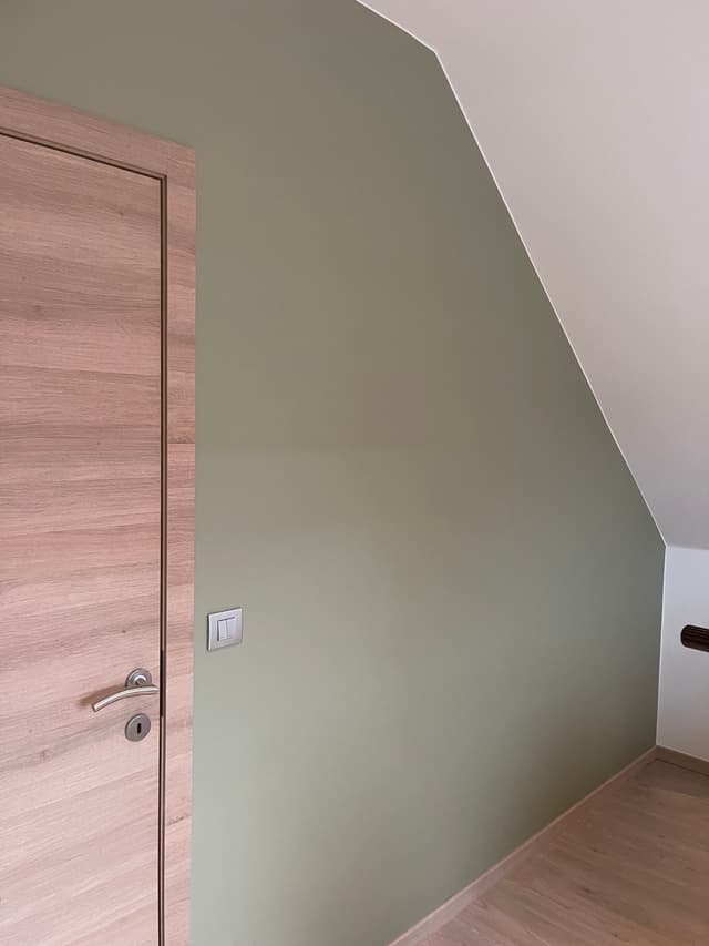 Een foto van een geschilderde muur met een deur aan de linkerkant.